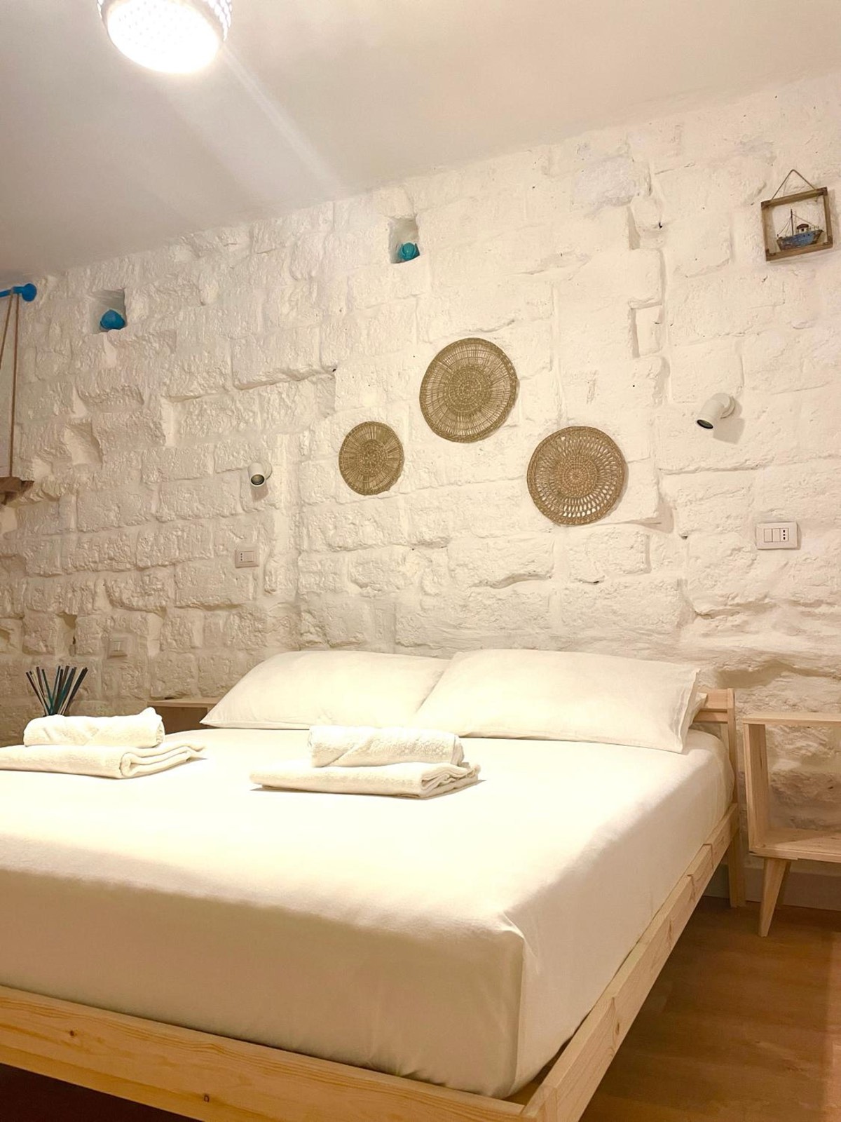 Il letto matrimoniale sotto il muro in pietra bianca