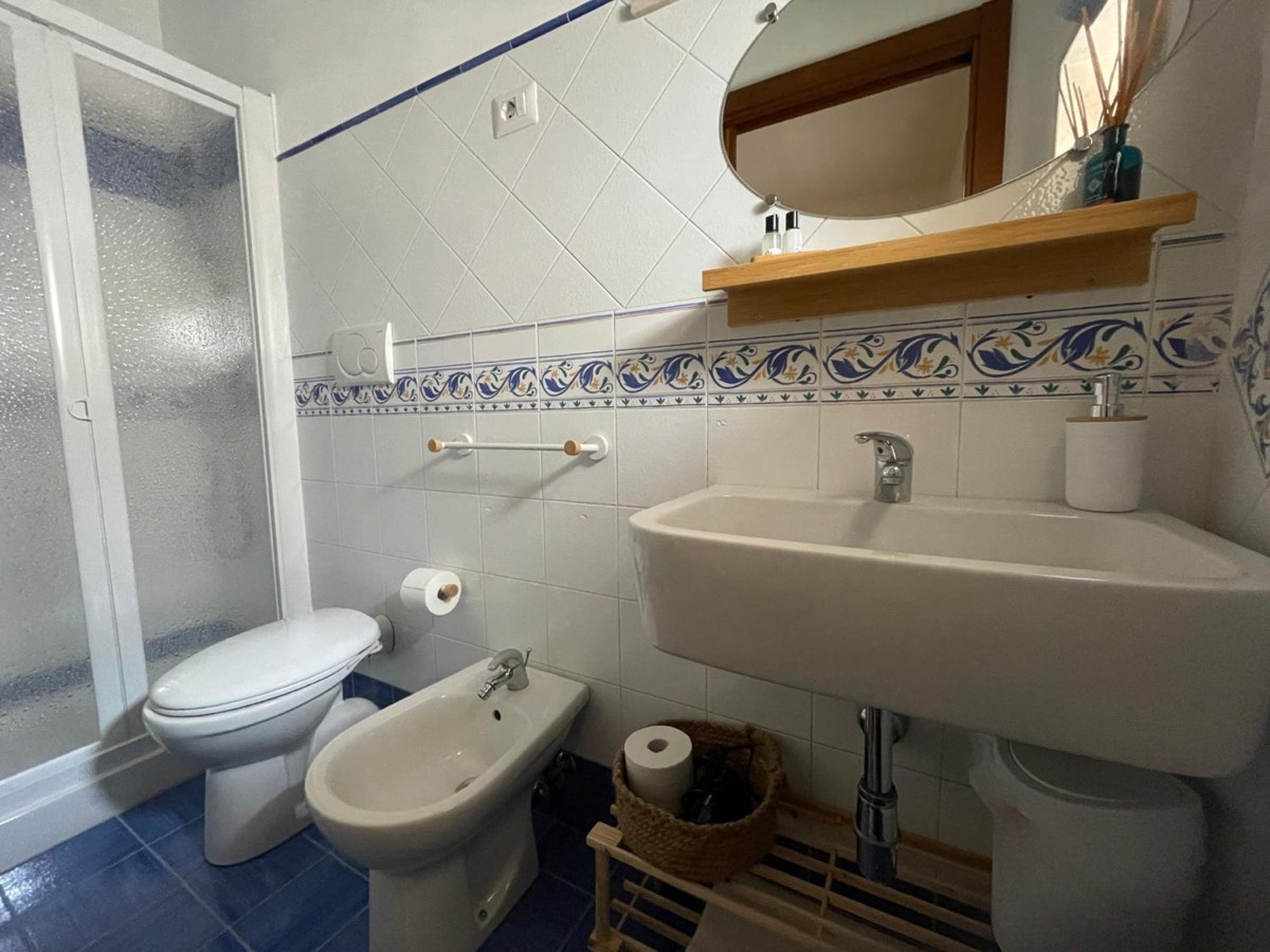 Il bagno: lavabo, bidet e la fascia di piastrelle blu e bianche