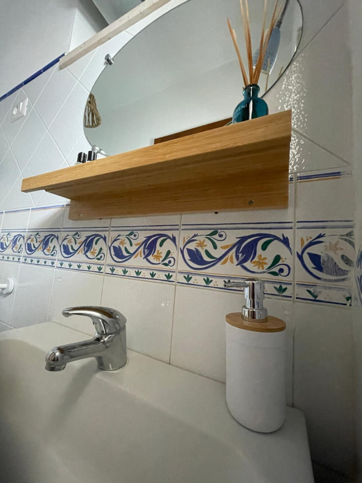 Il lavabo, una mensola di legno e le piastrelle blu e bianche