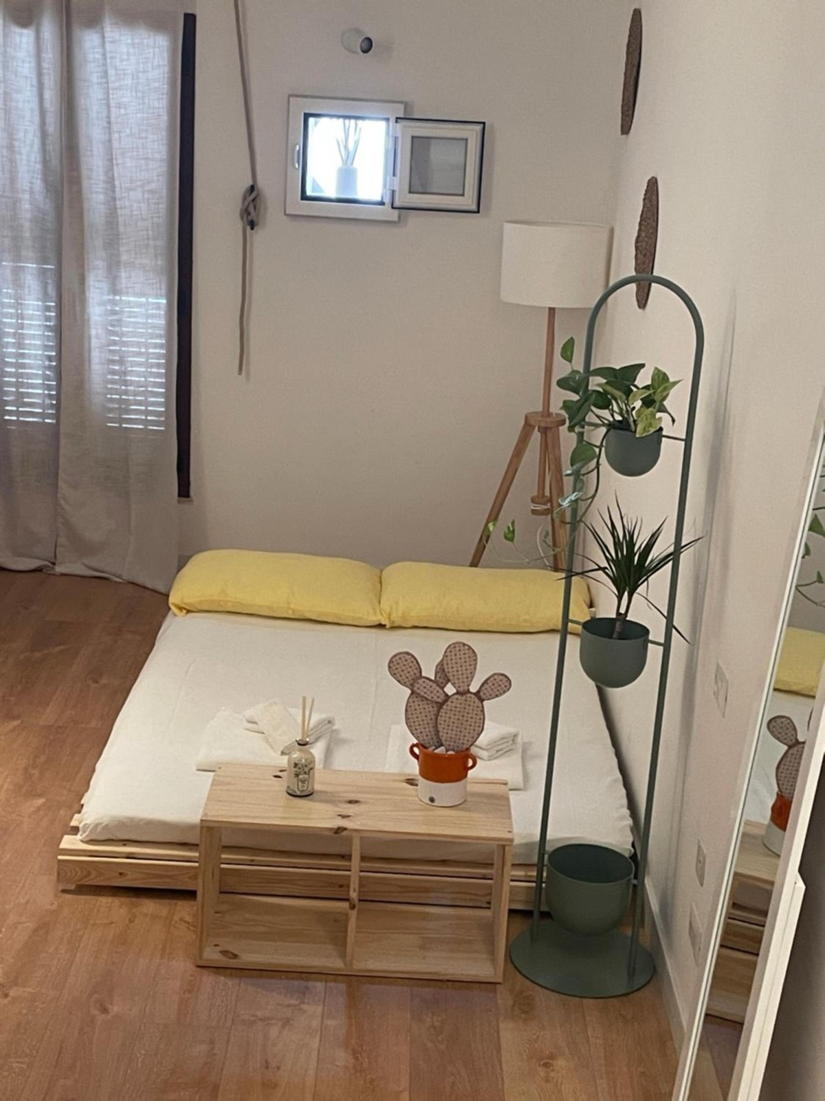 Il futon a terra con i cuscini gialli e un tavolino di legno