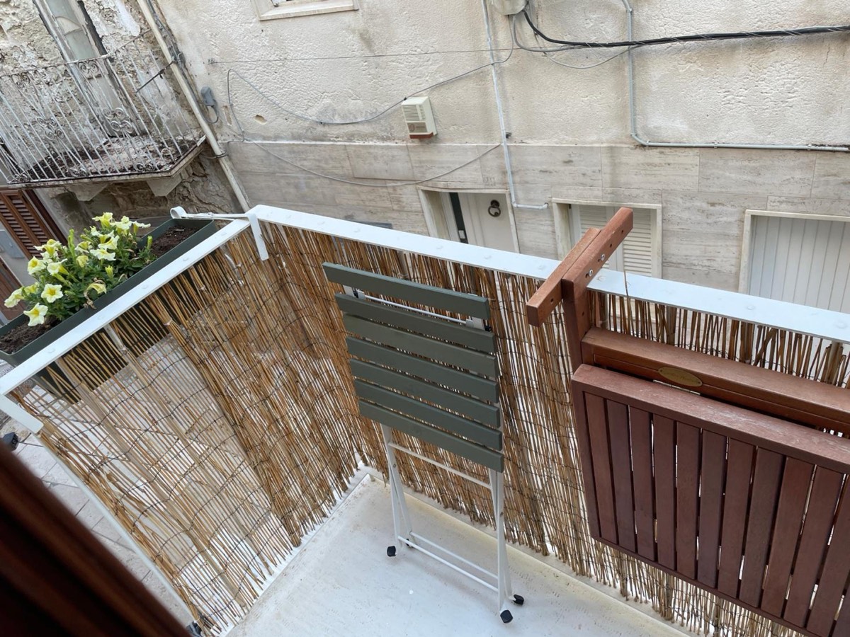 Il balcone con le stuoie di canne alla ringhiera e i fiori